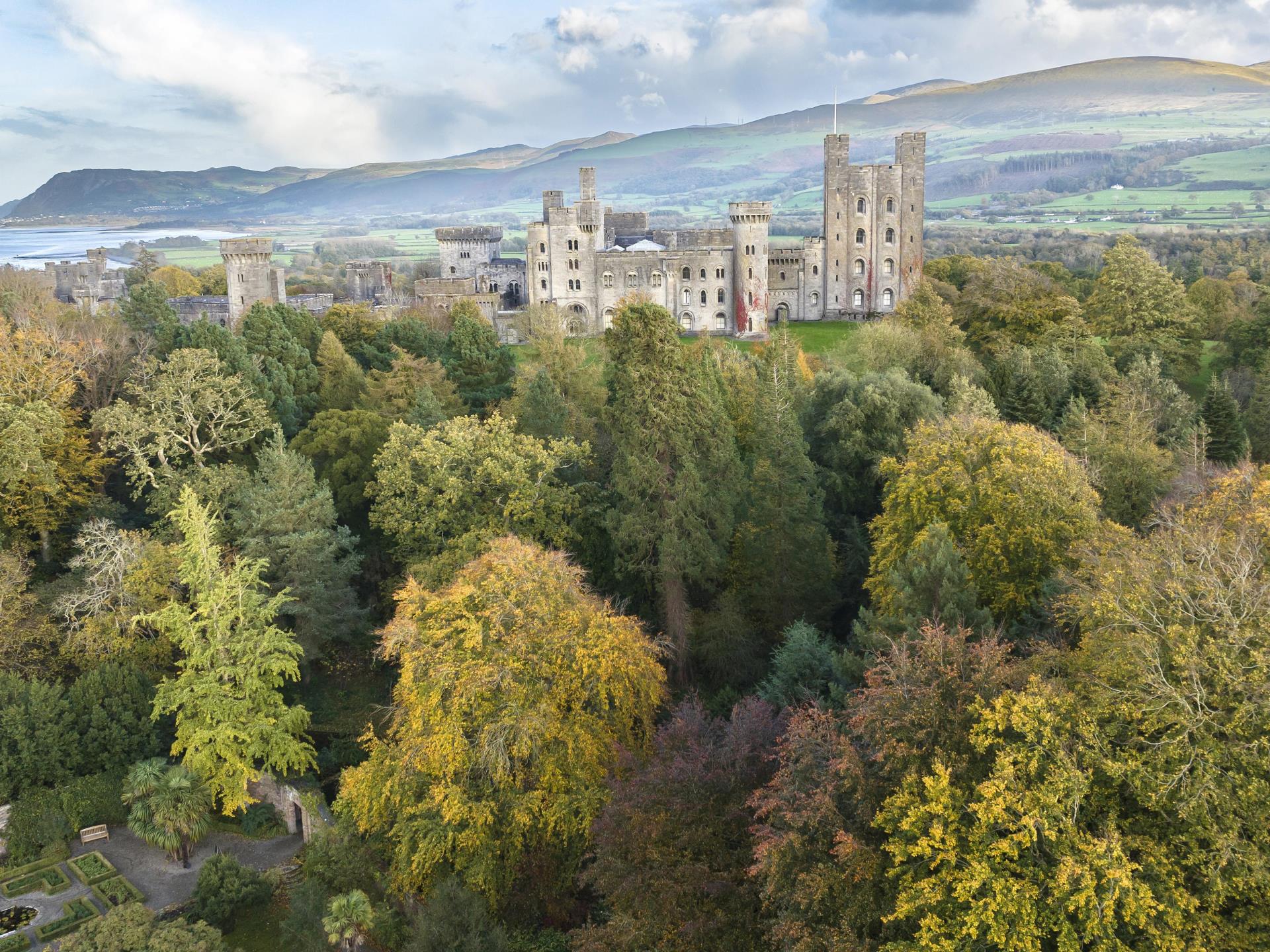 The autumnal trees surround Penrhyn Castle
