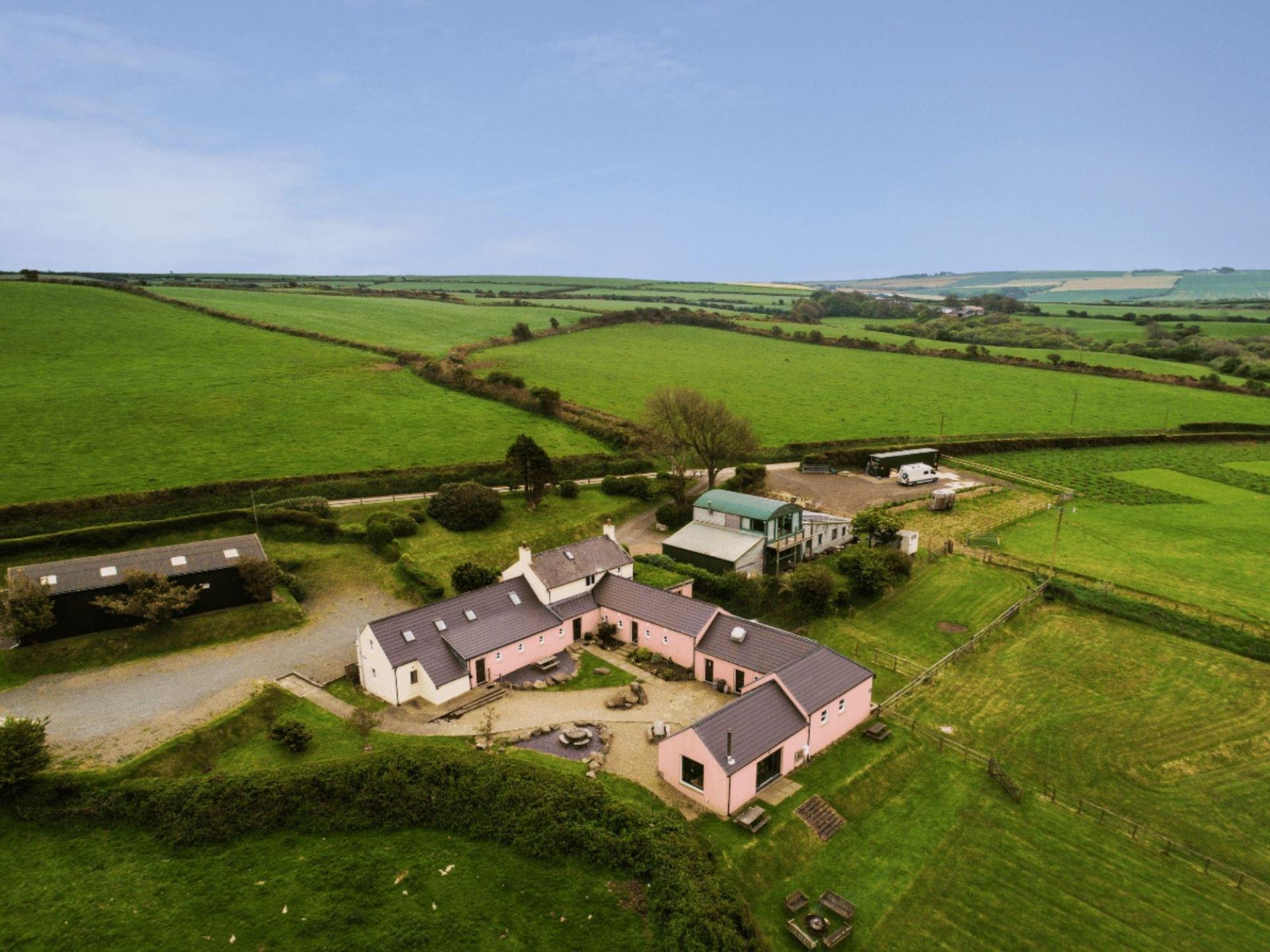 Eco Barn (green roof) & lodges (pink/white)